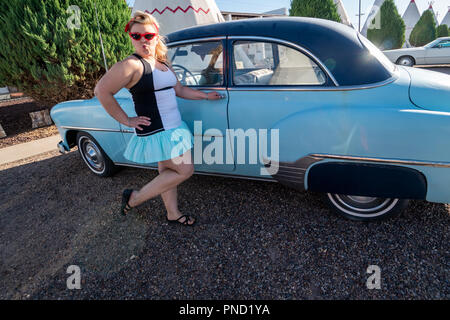 Blond erwachsenen Weibchen mit einem 1950er Jahrgang Pin up Frisur steht in der Nähe ein verlassenes Oldtimer, das Tragen von Cat eye Sonnenbrille Stockfoto