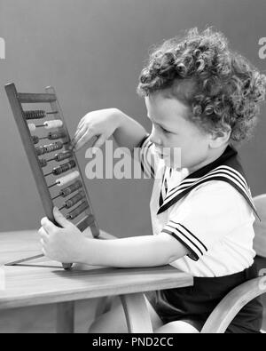 1940 s CURLY VORANGEGANGEN JUNGE TRAGEN SAILOR SHIRT SITZEN AM TISCH SPIELEN MIT SPIELZEUG ABACUS-j 9218 HAR 001 HARS BABY JUNGE JUNGEN SCHWARZEN UND WEISSEN KAUKASISCHEN ETHNIE HAR 001 VORANGEGANGEN ALTMODISCH Stockfoto