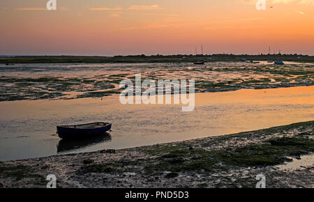 Sonnenuntergang bei Leigh On Sea Sümpfe mit Reflexionen im Wasser und Boote. Stockfoto