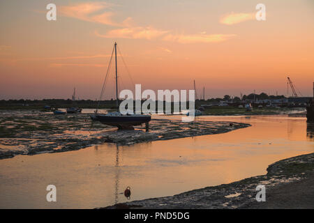 Sonnenuntergang bei Leigh On Sea Sümpfe mit Reflexionen im Wasser und Boote. Stockfoto