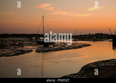 Sonnenuntergang bei Leigh On Sea Sümpfe mit Reflexionen im Wasser und Boote. Stockfoto