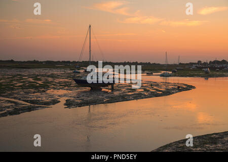 Sonnenuntergang bei Leigh On Sea Sümpfe mit Reflexionen im Wasser und Boote. Stockfoto