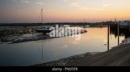 Sonnenuntergang bei Leigh On Sea Sümpfe mit Reflexionen im Wasser und Boote. Stockfoto