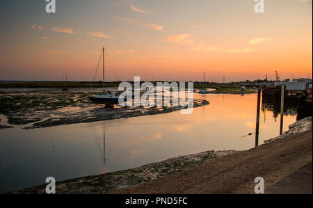 Sonnenuntergang bei Leigh On Sea Sümpfe mit Reflexionen im Wasser und Boote. Stockfoto