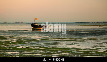 Sonnenuntergang bei Leigh On Sea Sümpfe mit Reflexionen im Wasser und Boote. Stockfoto