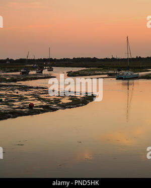 Sonnenuntergang bei Leigh On Sea Sümpfe mit Reflexionen im Wasser und Boote. Stockfoto