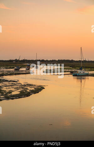 Sonnenuntergang bei Leigh On Sea Sümpfe mit Reflexionen im Wasser und Boote. Stockfoto