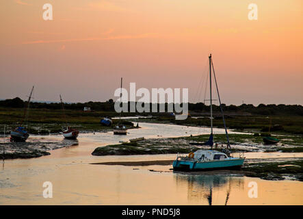 Sonnenuntergang bei Leigh On Sea Sümpfe mit Reflexionen im Wasser und Boote. Stockfoto