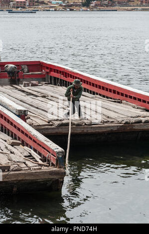 SAN PEDRO DE TIQUINA, Bolivien-Am 18. AUGUST 2017: Unbekannter indigenen Männer an einem Fluss Fähren am Ufer des Titicaca-see an der Straße von Tiqu Stockfoto