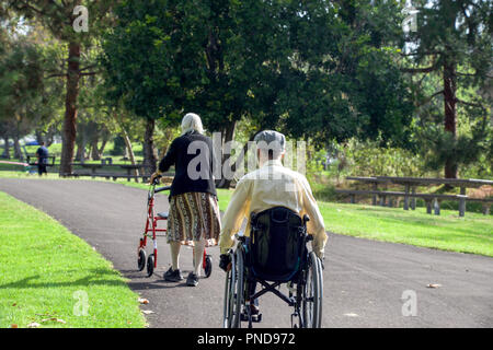 Älteres Ehepaar mit einem Rollstuhl & Walker ein Spaziergang in Yorba Regional Park in Yorba Linda, CA 2017 Stockfoto