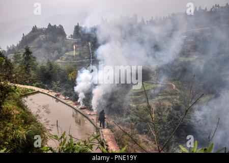 Terrassierten Reisfeldern in den hohen Bergen der Provinz Guizhou in China und der Feuerwerkskörper. Stockfoto