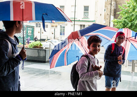 London England, Großbritannien, South Bank, Lambeth, Regen regnerischen Tag Wetter, Union Jack Flagge Farben Regenschirme, muslimische ethnische Jungen, männliche Kinder Kinder Kinder jung Stockfoto