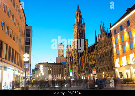 Menschen zu Fuß am Marienplatz und München City Hall in der Nacht in München. Cafés, Bars, Geschäften und Restaurants. Bewegung verwischt. Stockfoto