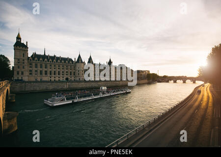 Touristische Bootsfahrt auf der Seine Fluss mit schönen Sonnenuntergang in Paris. Kreuzfahrtschiff Sehenswürdigkeiten entlang des Flusses in Paris, Frankreich. Stockfoto