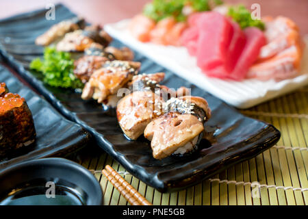 Sushi mit Stäbchen und Sojasauce. Sushi Roll japanisches Essen im Restaurant. Foie Gras Sushi mit Lachs, Thunfisch, Fliegen, keinen Fischrogen und Kaviar closeup Stockfoto