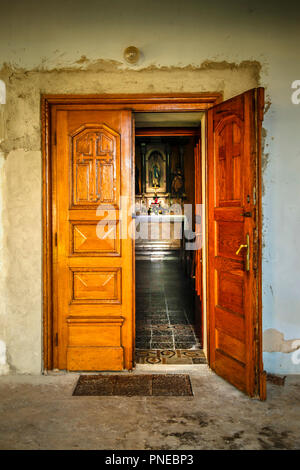 Eine offene Hand geschnitzte Holztür führt zu der in der Kirche der Heiligen Dreifaltigkeit in der Ortschaft Punat auf der Adria auf der kroatischen Insel Krk ändern Stockfoto