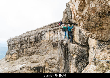 Zwei junge attraktive Bergsteiger auf sehr exponierten Klettersteig in Alta Badia in den Dolomiten Stockfoto