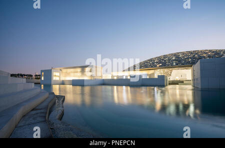 Außen am Abend Blick auf den Louvre Abu Dhabi auf Saadiyat Island Cultural District in Abu Dhabi, VAE. Architekt Jean Nouvel Stockfoto