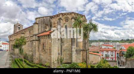 Eine Landschaft mit der Santa Maria Del Azogue Kirche (Iglesia de Santa Maria Del Azogue), einige Palmen und einem blauen bewölkten Himmel in Betanzos, Spanien Stockfoto