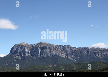 Eine Landschaft mit blauem Himmel, einige Wolken und die Peña Montañesa Bergmassiv in der spanischen Pyrenäen, wie von Ainsa, einer ländlichen Stadt gesehen Stockfoto