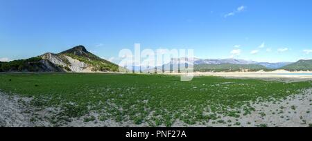 Eine grüne Landschaft der Mediano künstlichen See in den spanischen Pyrenäen wie aus dem Inneren der See aus gesehen, mit grünen frisches Gras, Spanien Stockfoto