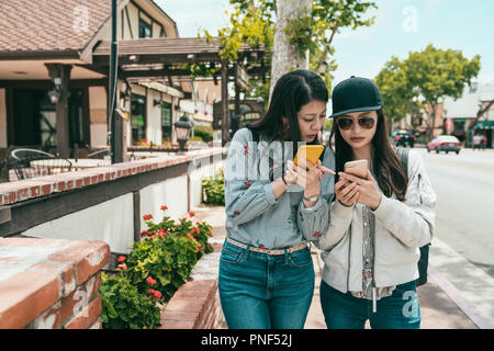 Hübsche Mädchen etwas diskutieren am Telefon, während auf dem Bürgersteig in der Stadt. Stockfoto
