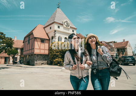 Zwei schöne Frauen, Sightseeing und Wandern in einem Raum in fornt für eine schöne und traditionelle Architektur. Stockfoto