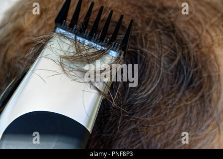 Ein Mann erhält ein Haarschnitt mit elektrischer Haarschneider statt Schere. Stockfoto
