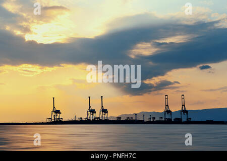 Osaka Hafen mit Kran Silhouette bei Sonnenuntergang. Japan. Stockfoto