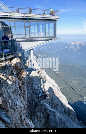 Grainau, Bayern. 21 Sep, 2018. Das beschädigte Kabel Auto der Zugspitz Seilbahn bis zur Bergstation der Zugspitze für Bergung gezogen. Noch nicht einmal ein dreiviertel Jahr nach der Inbetriebnahme, einem Unfall während einer Übung gelähmt Die neuen Zugspitzbahn. Während der Übung, eine Rettung Korb waren auf einen der beiden neuen Seilbahn Kabinen gehetzt. Credit: Matthias Balk/dpa/Alamy leben Nachrichten Stockfoto