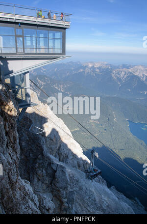 Grainau, Bayern. 21 Sep, 2018. Das beschädigte Kabel Auto der Zugspitz Seilbahn bis zur Bergstation der Zugspitze für Bergung gezogen. Noch nicht einmal ein dreiviertel Jahr nach der Inbetriebnahme, einem Unfall während einer Übung gelähmt Die neuen Zugspitzbahn. Während der Übung, eine Rettung Korb waren auf einen der beiden neuen Seilbahn Kabinen gehetzt. Credit: Matthias Balk/dpa/Alamy leben Nachrichten Stockfoto