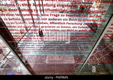 21. September 2018, Nordrhein-Westfalen, Duisburg: Die Fenster der Lehmbruck-Museum, bezeichnet der Begriff Künstler Jochen Gerz, werden durch einen Handel Besucher angezeigt. Der Künstler thematisiert acht Jahrzehnte der Zeitgeschichte von 1940 bis 2010, und die Besucher können den Blick in die Ausstellung "Der Spaziergang" von 23.09. bis 05.05.2019. Foto: Roland Weihrauch/dpa Stockfoto