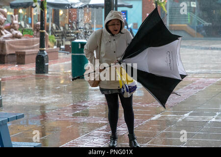 Stadtzentrum Warrington, Cheshire, England, Großbritannien - 21 September 2018 - Wetter - am späten Nachmittag und die Windstärke Winde der Sturm Bronagh, der zweite Sturm der britischen Winter innerhalb von Tagen, erhöhten ihre Intensität, mit Böen von über 50 mph in Warrington, Cheshire. Bild: Menschen kämpfen, um ihre Schirme richtig in den Wind zu halten. Stockfoto