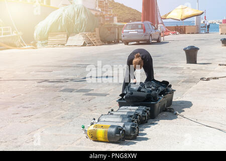 Diver Kontrollen Sauerstoffflaschen für Tauchen auf der Pier. Volle Sauerstoffflaschen und Tauchausrüstung bereit zu tauchen. Stockfoto