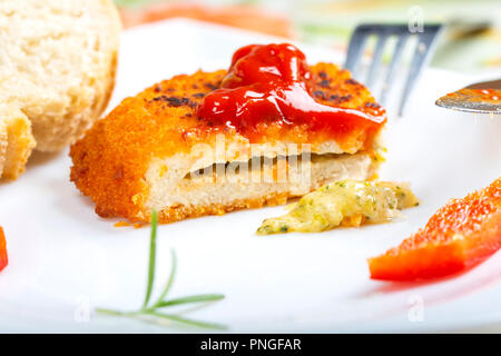 Hähnchen Cordon Bleu auf Platte mit Tomatensoße oder Ketchup - Nähe zu sehen. Stockfoto