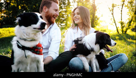 Ein junges Paar zu Fuß ein Hund im Park Stockfoto