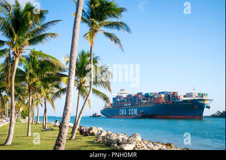 MIAMI, USA - ca. August 2018: Container Freight ship" CMA CGM MUSSET' Eingabe der Port durch eine schmale, Palm-Kanal an der Spitze von South Beach umgeben Stockfoto