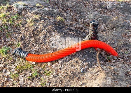 Rot Orange Wellpappe Ummantelung für elektrische Leitungen, auf ein Gebäude Baustelle Stockfoto