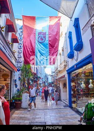 Bodrum, Türkei - Juli 5, 2018. Ein Mann, der auf der Flagge der türkische Fußball-Verein Trabzonspor in einer Straße in der Innenstadt. Provinz Mugla, Türkei. Stockfoto