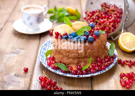 Torte mit Heidelbeeren und Johannisbeeren auf zum Frühstück. Hausgemachtes Gebäck mit Beeren und Kaffee am Morgen auf einer hölzernen Hintergrund. Platz kopieren Stockfoto