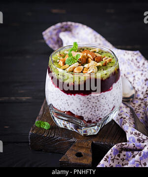 Chia Milchreis mit frischen Beeren, Nüsse und Minze im Glas. Нealthy Frühstück. Stockfoto