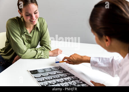 Geduldig lächelnd über CT Scans bei X-ray. Mittellange Aufnahme. Stockfoto