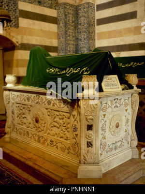 Mausoleum Saladins oder An-Nasir Salah ad-Din Yusuf ibn Ayyub (1137-1193). Erste Sultan von Ägypten und Syrien. Gründer der Ayyubid Dynastie. Er war in einem Mausoleum im Garten außerhalb der Omaijadenmoschee in Damaskus, Syrien begraben. Sieben Jahrhunderte später, Kaiser Wilhelm II. von Deutschland stiftete einen neuen Marmor Sarkophag zu dem Mausoleum. Allerdings ist die ursprüngliche Sarkophag wurde nicht ersetzt, sondern das mausoleum hat jetzt zwei sarkophage: den Marmor eines auf der Seite und das ursprüngliche Holz-, die Abdeckungen des Saladin Grab gelegt. Damaskus. Syrien. Stockfoto