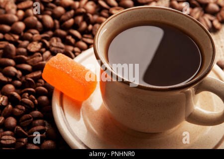 Tasse Kaffee mit Marmelade auf dem Hintergrund der Kaffeebohnen. Stockfoto