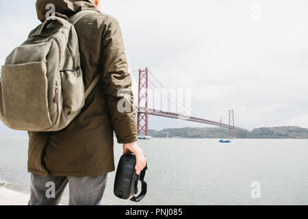 Der Mann hält die virtual reality Brille und schaut am 25. April in Lissabon. Das Konzept der Virtuellen reisen. Das Konzept der modernen Technologien und deren Einsatz im täglichen Leben. Stockfoto