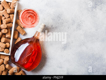 Flasche und Gläser pink rose Wein mit Box von Korken auf Stein Küchentisch Hintergrund. Ansicht von oben. Stockfoto