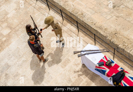 Touristen in Militäruniformen auf Salutierte Batterie am oberen Barraka Gardens gezeigt, wie Gewehre zu laden gekleidet. Stockfoto