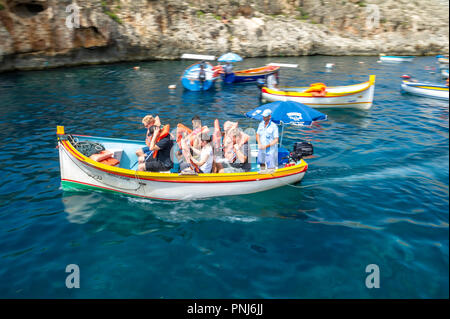 Touristen ein Ausflug zur Blauen Grotte in kleinen Booten auf Malta. Stockfoto