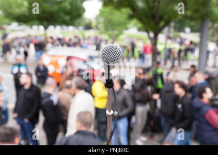 Mikrofon im Fokus, unscharfen Menge im Hintergrund. Eine politische Kundgebung oder andere öffentliche Demonstration, oder einen Protest. Stockfoto