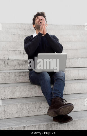 Das Gewinnen junger Mann mit Computer Stockfoto